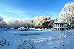 Zugefrorener Gartenteich im verschneiten NaturaGart Park