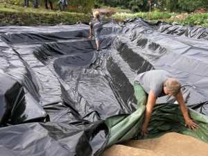 NaturaGart-Sicherungsfolie wird als Erosionsschutz in die Teichgrube gelegt