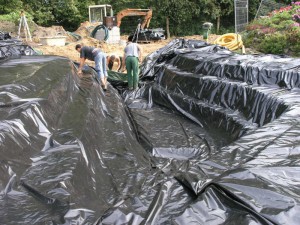 Regenjacke für den Teich: Die Sicherungsfolie wird über die Baugrube gelegt
