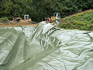 Abdichtungsfolie wird in die Teichgrube gelegt